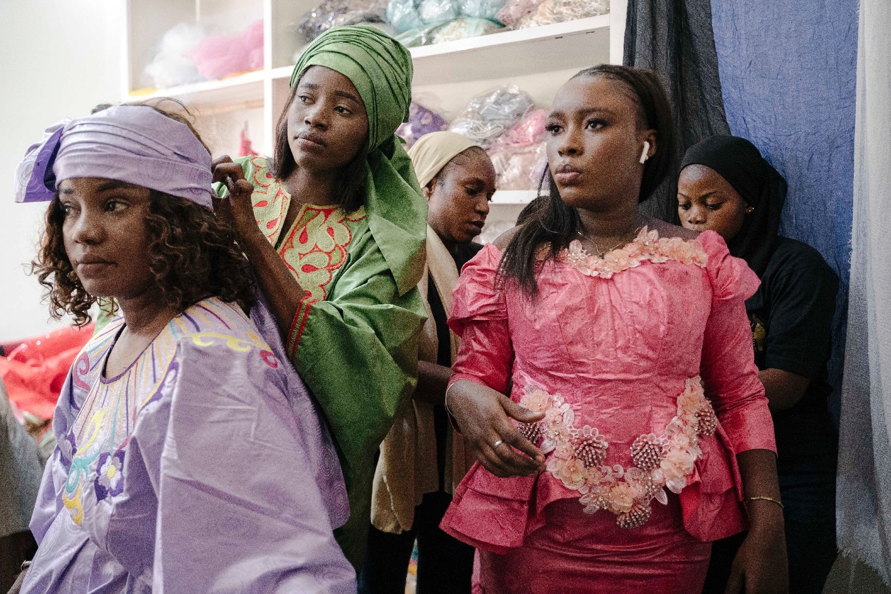 Des femmes essaient des robes dans une boutique de seconde main à Rufisque, dans la banlieue de Dakar, le 6 juin 2024 au Sénégal